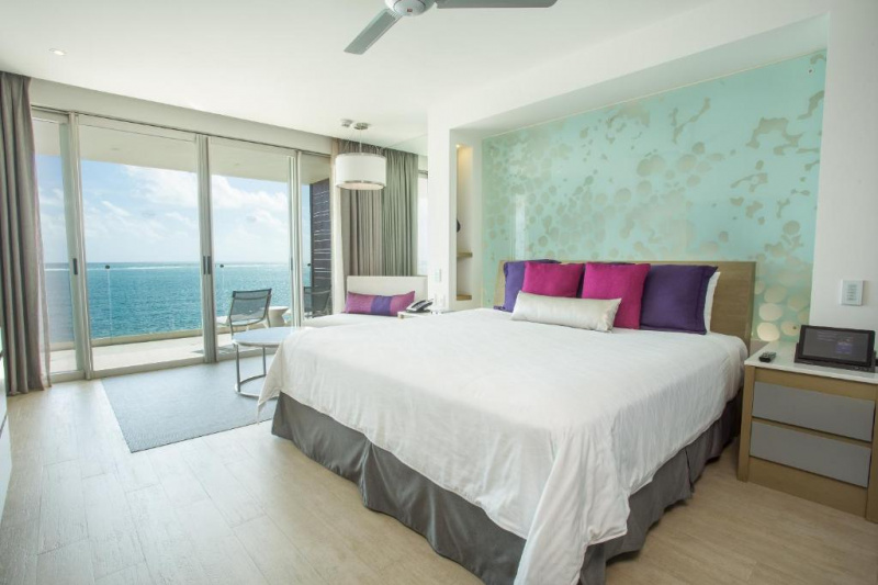 The spacious room has 1 king-sized bed with nightstands, a chair and a coffee table. The room has French doors leading to a furnished balcony.