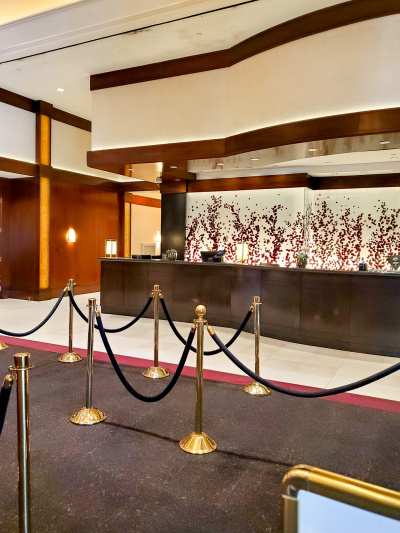 The spacious reception area has a high check-in desk and queue barriers.