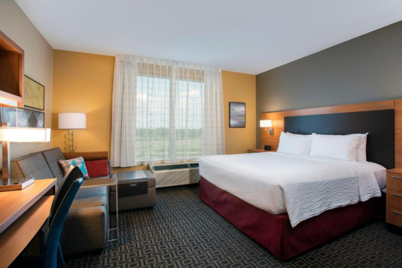 The spacious room has one king-sized bed with nightstands, one sofa bed, a pouffe, a workstation and a chair.