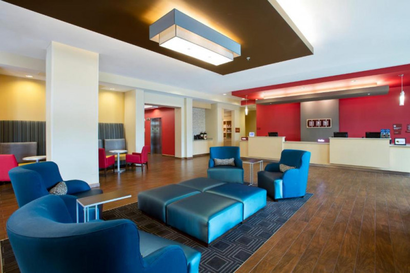 The spacious reception area has assorted tables and chairs. The check-in desk is high with a lowered section.