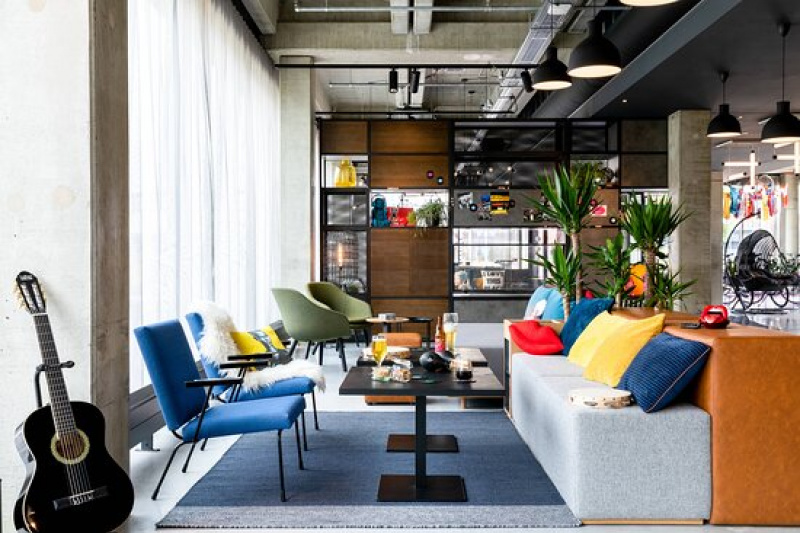 The seating area has a plush bench seat, assorted tables and movable chairs. There is limited floor space.