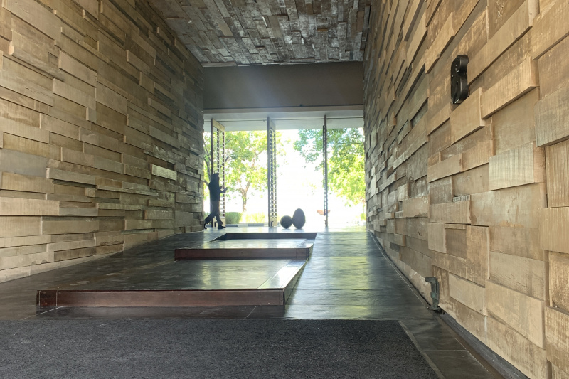 There is a long tiled corridor. In the centre of the corridor there are 3 steps with ramps on either side.
