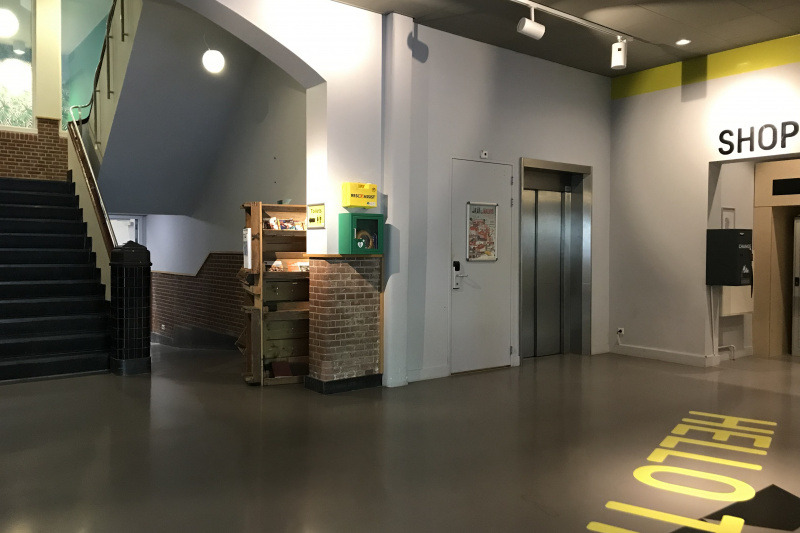 The spacious lobby leads to the hostel shop. There is an elevator and a flight of stairs leading to the next level.