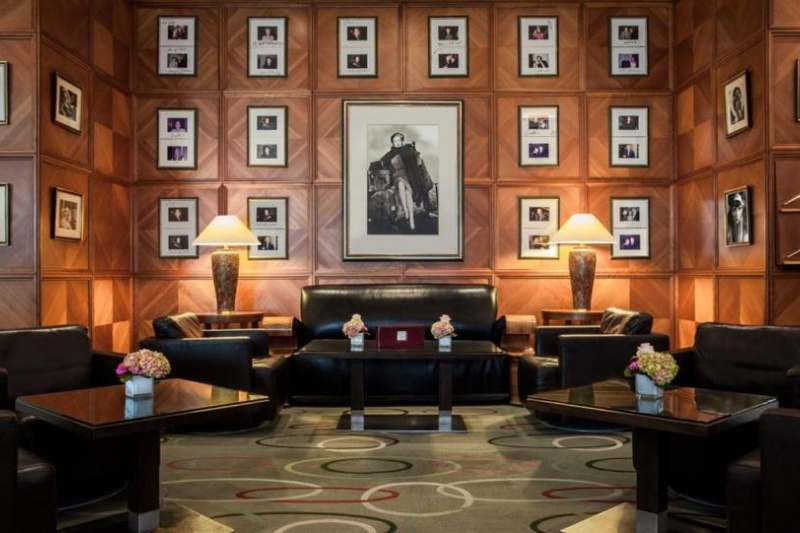 The seating area is in a spacious, wood-paneled room. There are several sets of leather sofas and chairs.