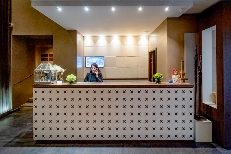 The hotel has a reception desk with a high counter. The area in front of it is step-free. There are stairs to one side.