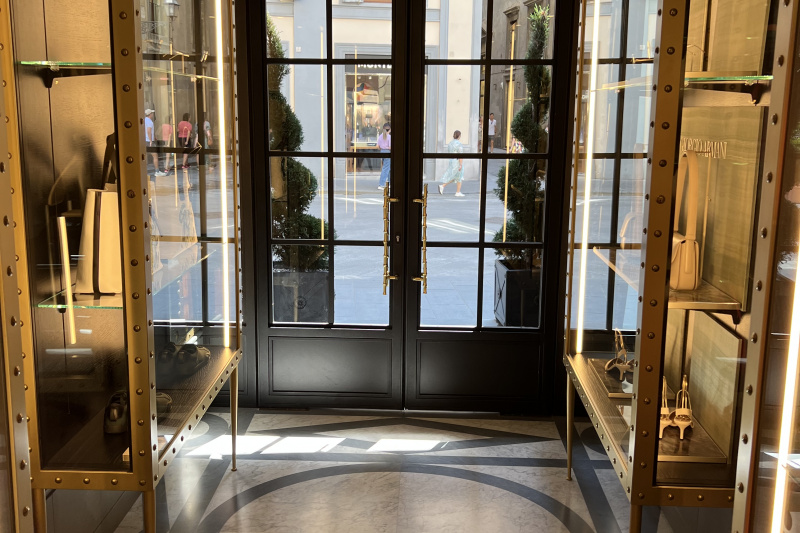 Double glass panelled doors provide access to the sidewalk from the step-free hotel lobby, which is a wide aisle lined with display cases.
