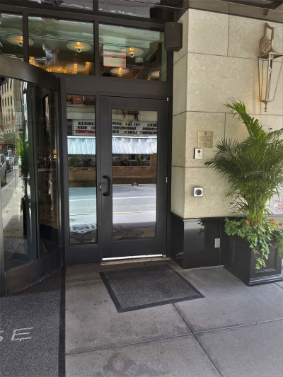 At the main entrance, a glass door with a large button to open it, provides accessible access to the hotel lobby from the sidewalk.