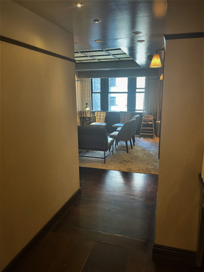 A small, step-free corridor leads to a seating area with a highchair and movable chairs.