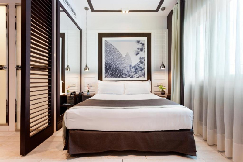 This hotel room has a full-sized bed with nightstands. Floor space around the bed is limited.