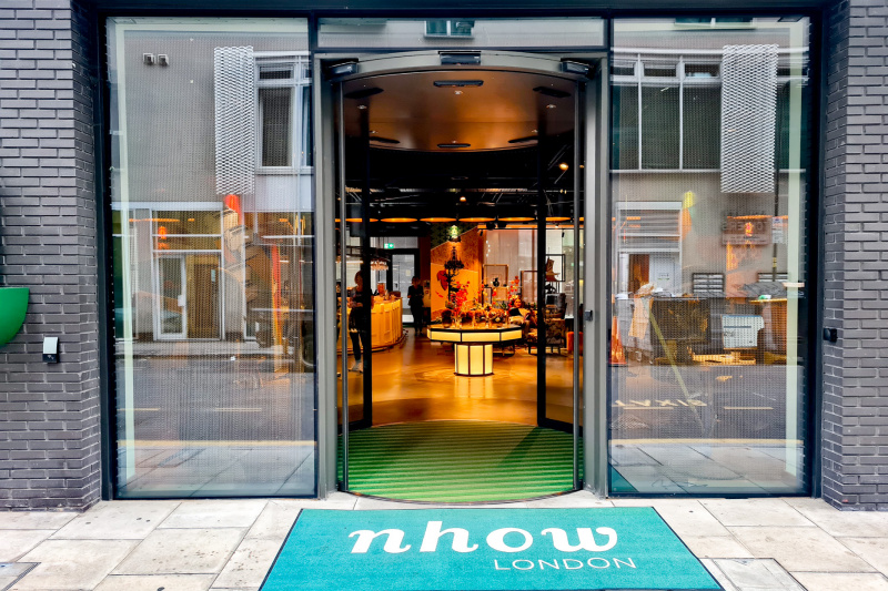The entrance to the hotel is from the sidewalk. There is a set of open, circular glass doors leading to the lobby.