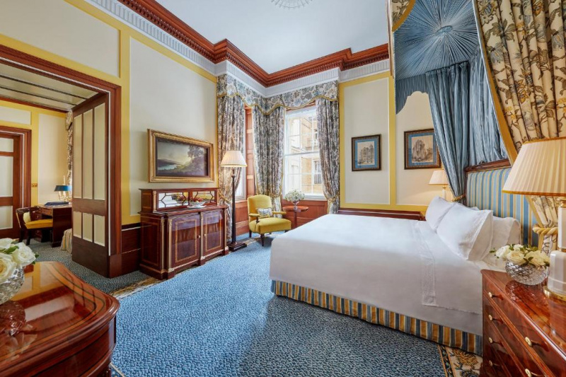 This very spacious carpeted room has 1 king sized bed. There are 3 cabinets in the room and a separate seating area with a workstation and a chair.