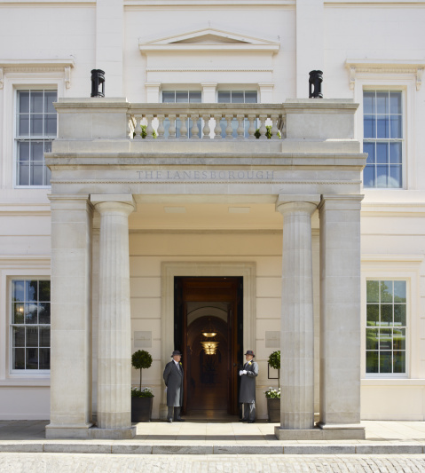 Entrance to the hotel is from the sidewalk. There is a grand, covered doorway with 2 doormen. The road has a high curb.