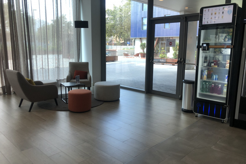 The spacious seating area has 2 movable chairs, 2 pouffes, and a small table. There is an emergency exit door.