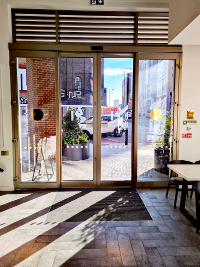 Automatic sliding glass doors lead from the lobby onto the paved sidewalk.
