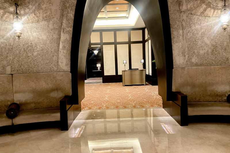 The spacious step-free lobby has low built-in seating. There is an archway leading to the reception desk.