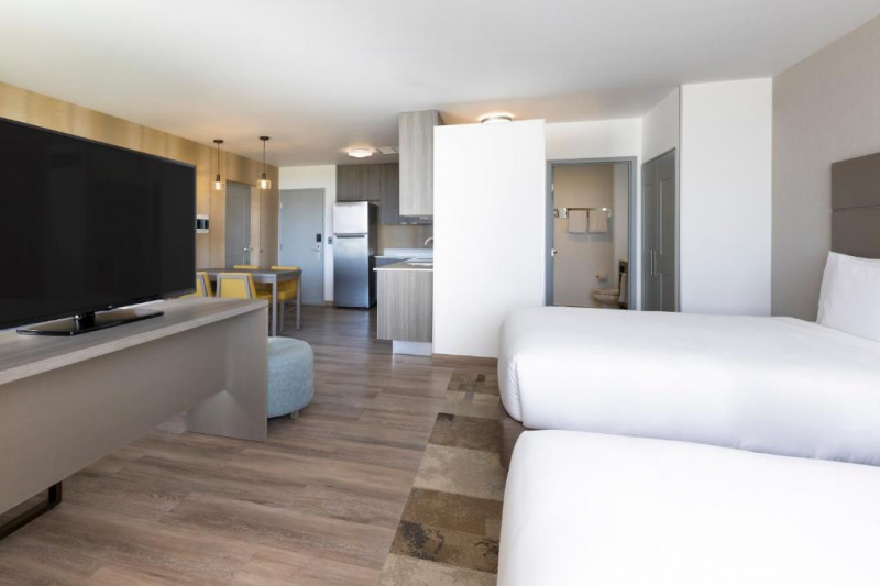 This spacious, step-free room has 2 queen-sized beds. Opposite the beds is a table with a TV. There is a kitchen and an ensuite.