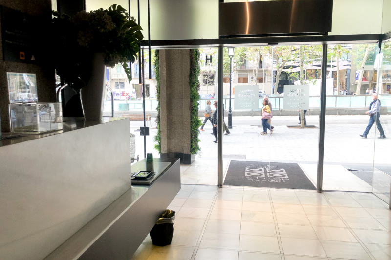 The reception desk is close to the entrance, in a spacious, step-free lobby. The desk has a high counter and a low section with a water cooler.