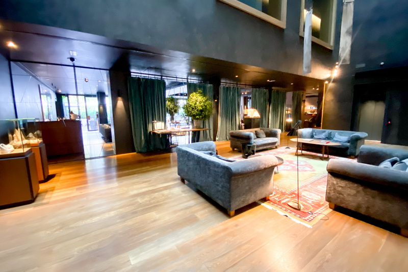 The spacious, step-free lobby area has 4 big sofas placed on each side of a carpet.