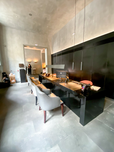The step-free, spacious reception area has a low check-in desk with 4 chairs in front of it.