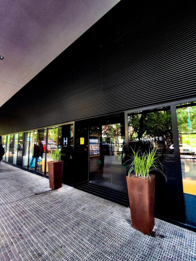 The paved sidewalk leads to the hotel entrance. In front of the sliding doors there is a non slip doormat.