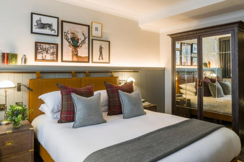 This small room has a full-sized bed with nightstands and wall-mounted reading lamps. The closet has mirrored doors.