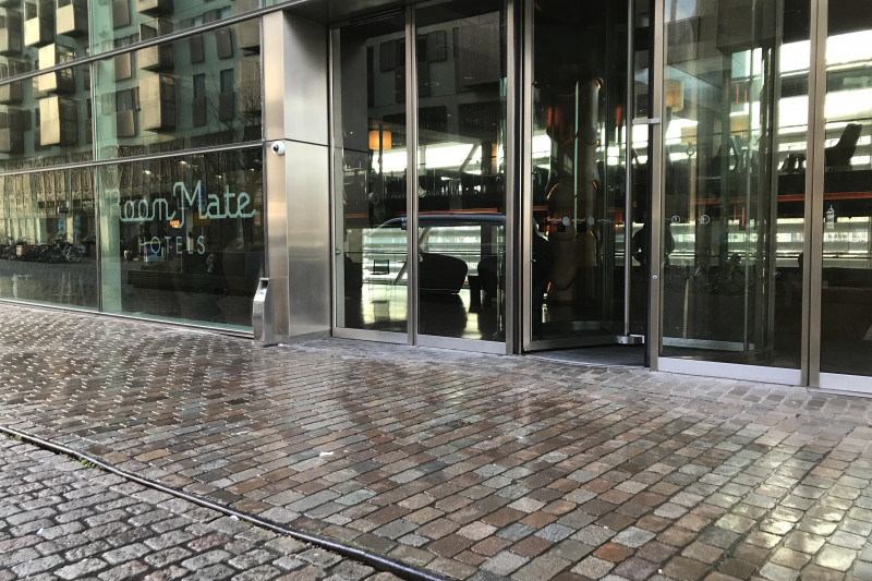 There is a cobbled sidewalk leading to the hotel entrance. Access to the hotel is through a revolving door.  There is a large manual door next to it.