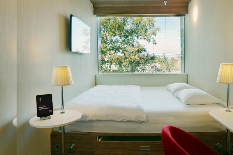 This tiny room has 1 full-sized bed. There is only access from one side of the bed. There is a table, storage space under the bed, and a workstation.