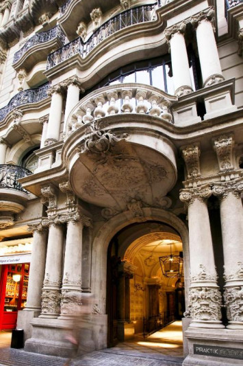 The hotel entrance is from the sidewalk. There is a wide corridor with a handrail inside the hotel.