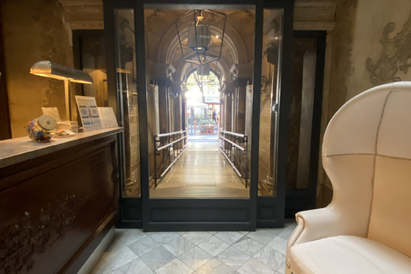 The reception area has a high check-in desk and a large armchair.