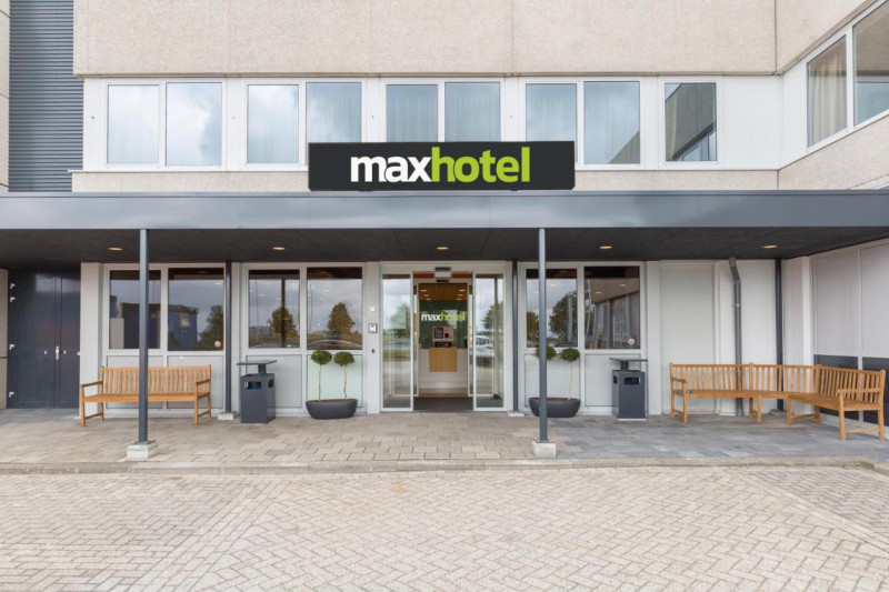 Access to the hotel is through 2 glass sliding doors. There are wooden benches outside the hotel and a small curb onto the sidewalk.