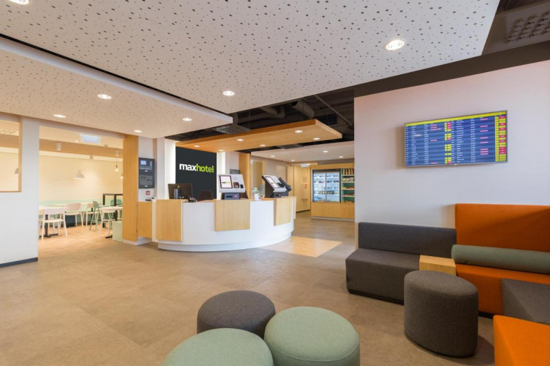 The spacious reception area has a high check-in desk, assorted tables and chairs, as well as a refrigerator with drinks and snacks.