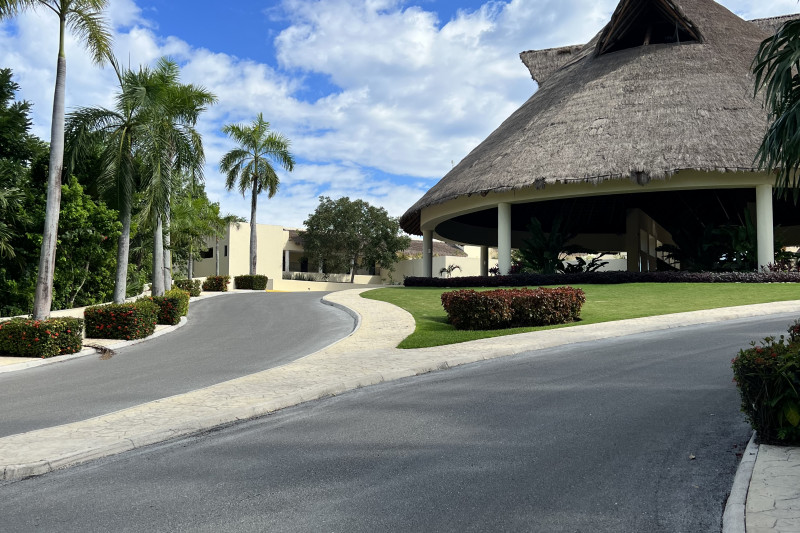 There are 2 roads with a big thatched building in the center.
