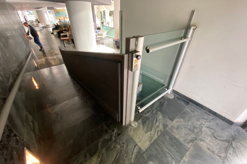 There is a ramp with a handrail and a wheelchair lift.