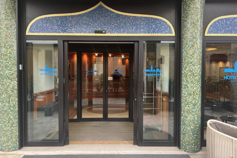 There are 2 sets of automatic glass doors leading from the sidewalk to the hotel lobby.