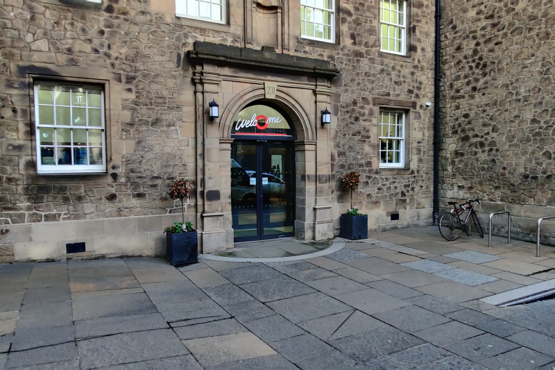 Entrance to the hotel is from a wide, step-free paved area. There is a set of automatic glass doors leading to the lobby.