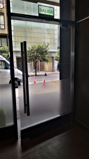 The hotel entrance is step-free and has a manual door that opens onto the sidewalk.