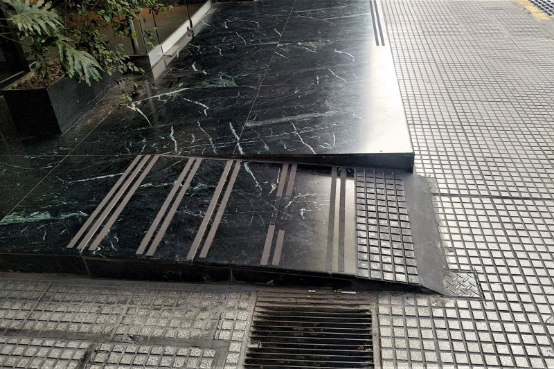 There is a small ramp leading from the sidewalk to the entrance of the hotel. There are no handrails.