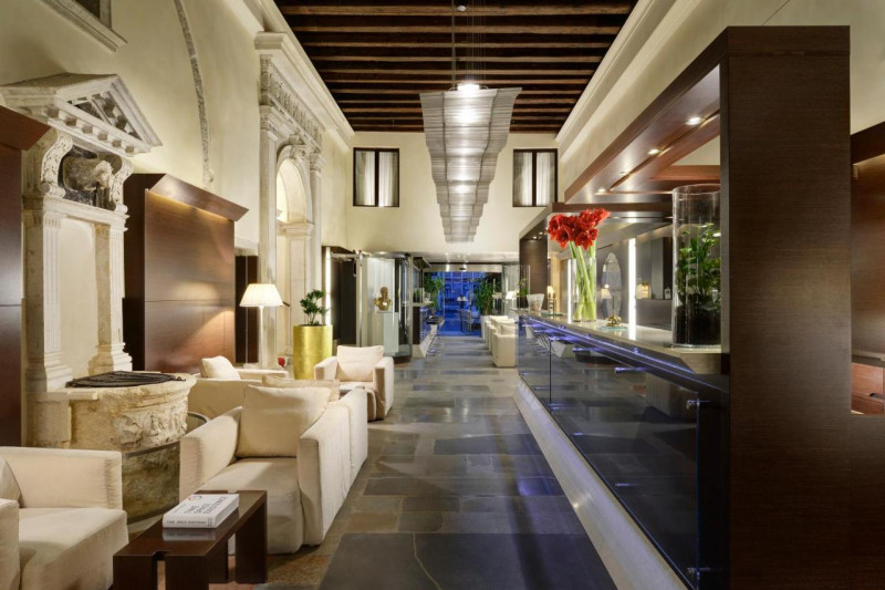The spacious, step-free reception area has assorted tables, chairs, and sofas. There is a bar area with high bar stools.