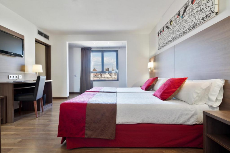 This spacious room has twin beds, a workstation, a chair and a wall-mounted TV.
