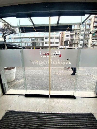 There is a non-slip doormat in front of the automatic sliding doors, leading from the sidewalk into the lobby.
