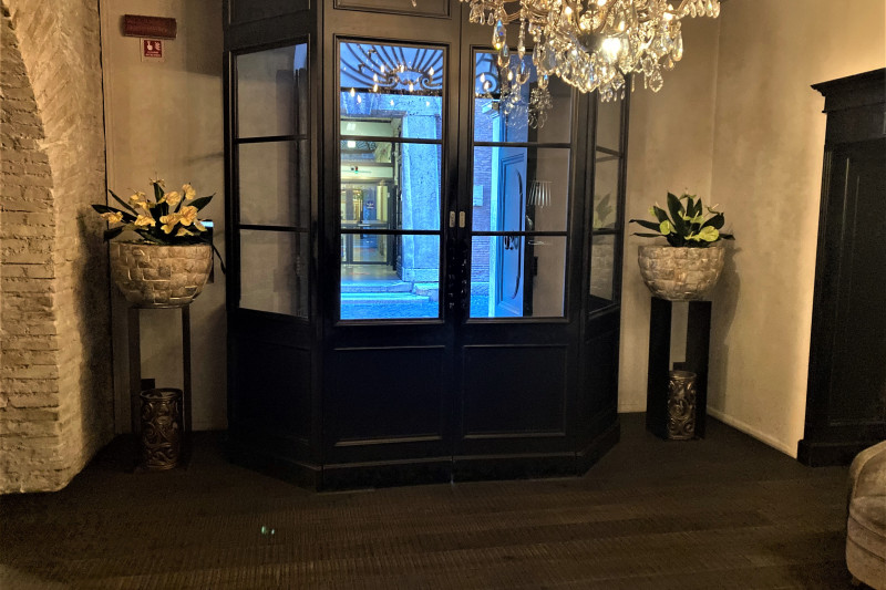 There is a set of closed manual doors leading from the lobby to the sidewalk.