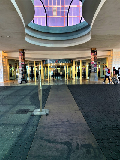 The entrance to the hotel is from a covered walkway. There is a large glass door leading into the lobby.