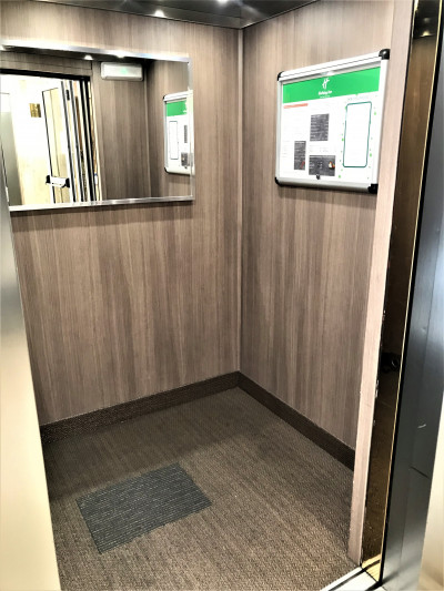 The spacious elevator has a mirror on the back panel. There are no handrails.