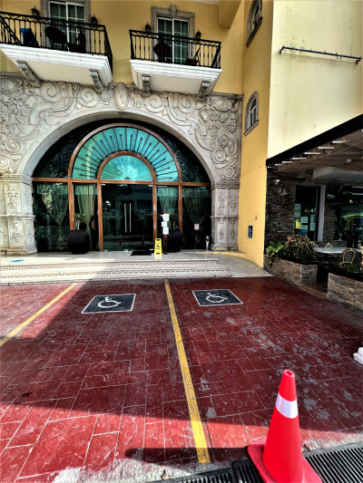 There are 2 accessible parking spaces in front of the hotel entrance. There are 2 small steps leading to the doors, with a ramp next to them.