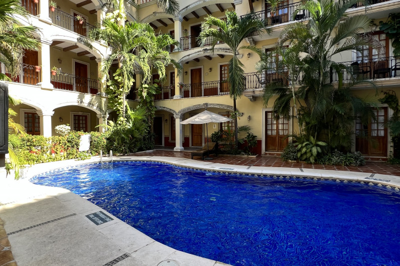 The outdoor pool has a long handrail. There is plenty of space around the poolside.