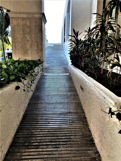 The outdoor ramp is very long and quite steep. There are walls on either side of it.