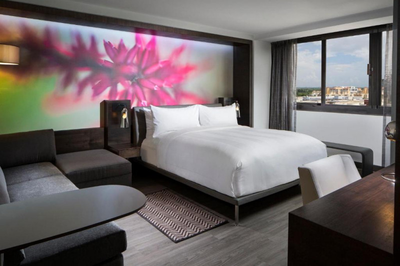 This room has 1 king-sized bed with nightstands. There is also a workstation, a chair, a pouffe, and a sofa.