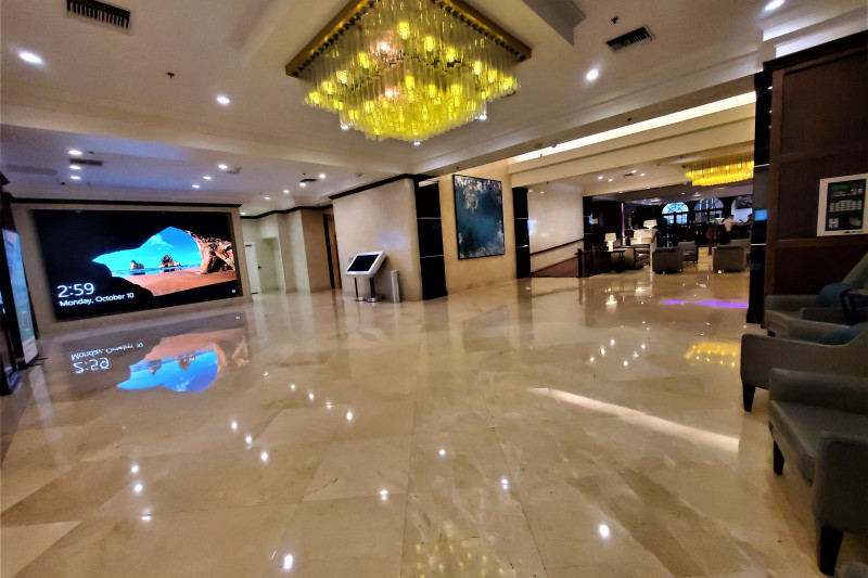 The spacious, step-free lobby has assorted tables and sofas. There is a small ramp with a handrail leading to another seating area.