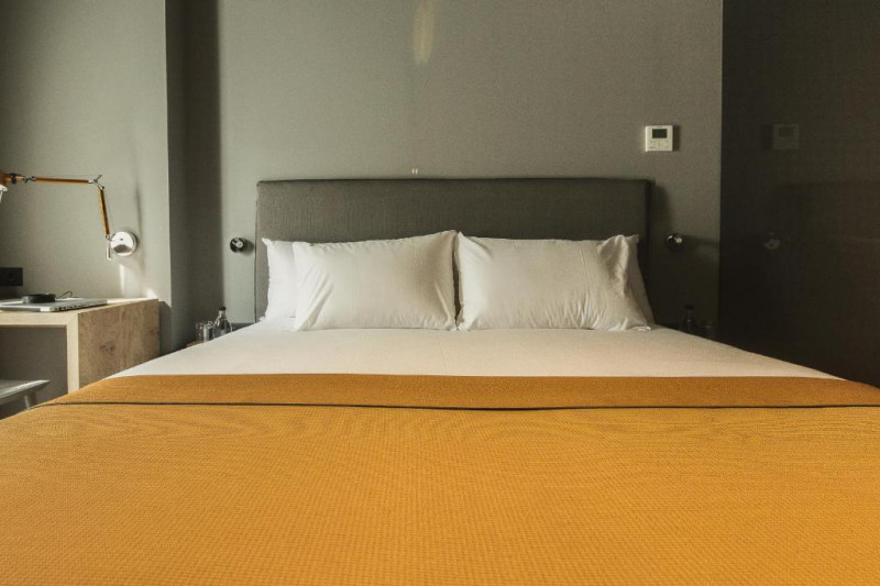 The room has 1 full-sized bed with nightstands. There is a workstation and a chair.