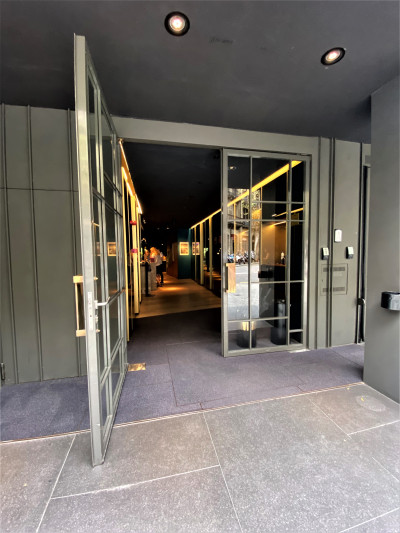 Access to the hotel is from the step-free sidewalk. A step of double doors leads to a long corridor leading to the reception area.
